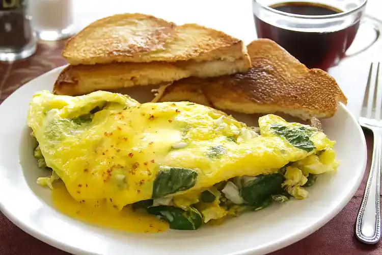 Crab omelette with toast and coffee on a white plate at Village Baker.