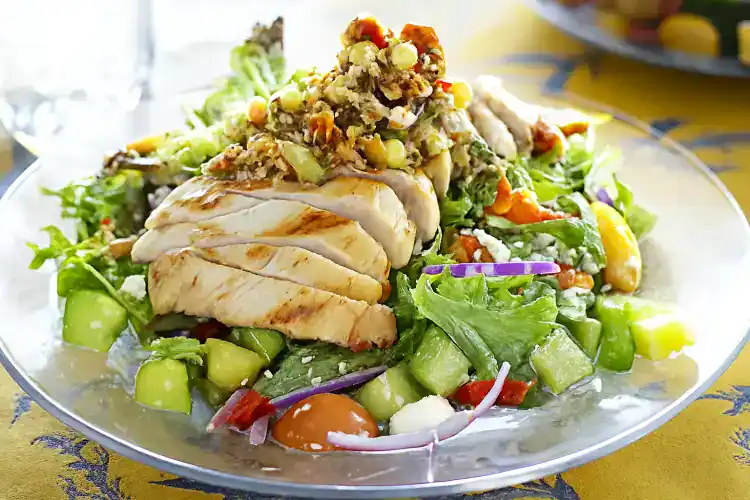 Healthy grilled chicken salad with mixed greens and colorful vegetables.