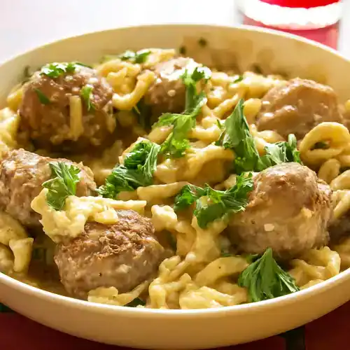 Meatball Spaetzle with parsley in a bowl, close-up.