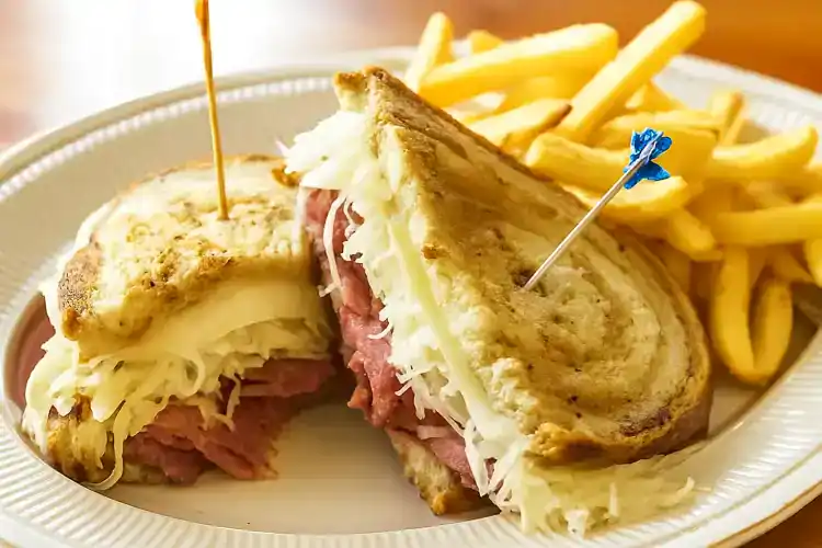 Delicious Reuben sandwich with melted cheese, corned beef, and sauerkraut on toasted bread.