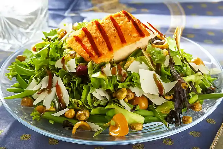 Fresh seared salmon on a bed of mixed greens and vegetables.