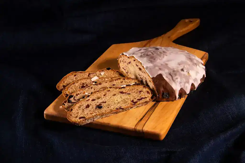 Freshly sliced fruit and nut bread on a wooden cutting board.
