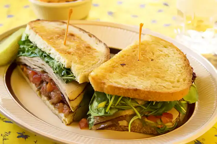 Delicious turkey bacon bruschetta on toasted bread with fresh greens and toppings.