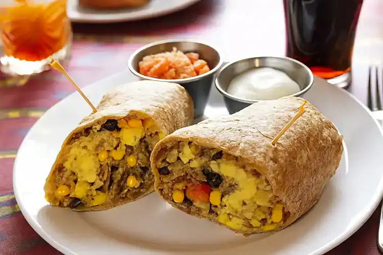 Freshly made breakfast burrito with corn, beans, and vegetables from Village Baker.