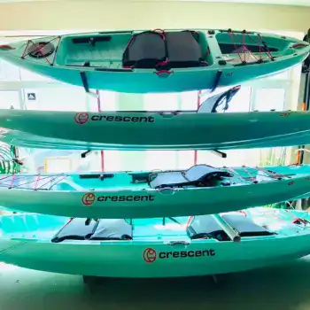 Multiple Crescent kayaks and paddleboards displayed indoors at WaterDog Outfitters.