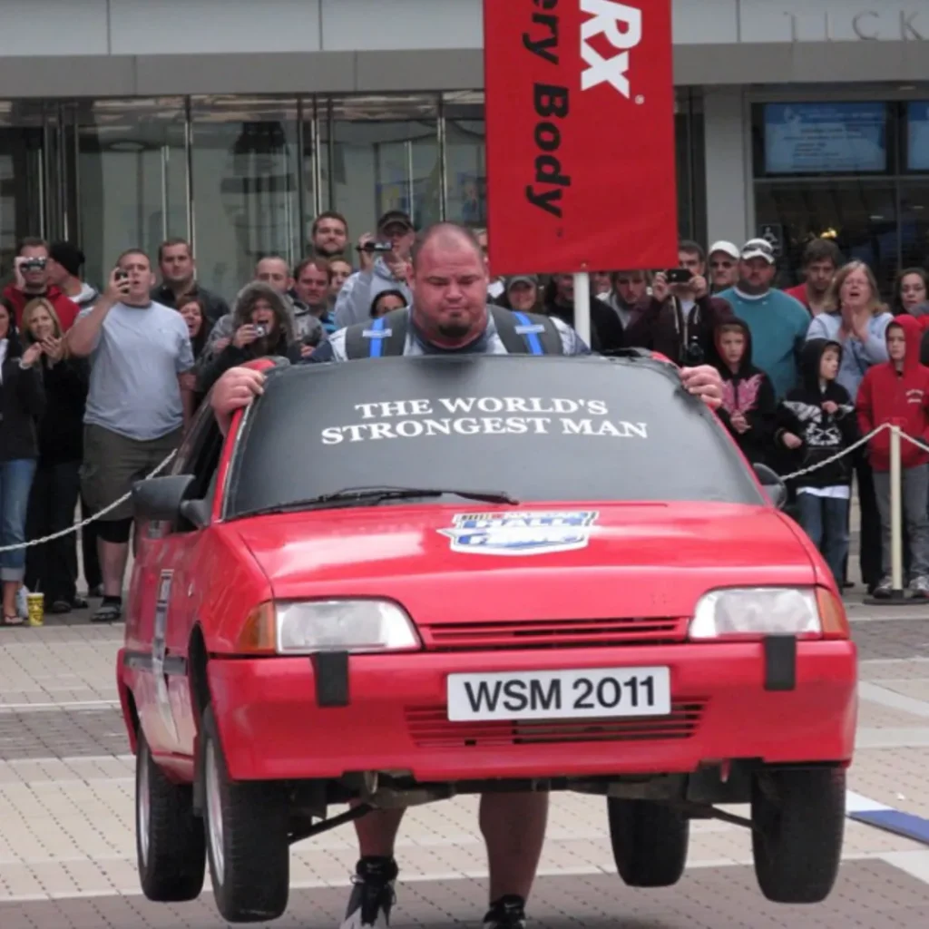 Brian Shaw net worth: Shaw lifting a car at 2011 Worlds Strongest Man