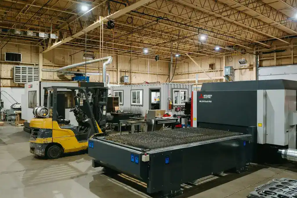 Industrial manufacturing facility with CNC machines and forklift in operation.