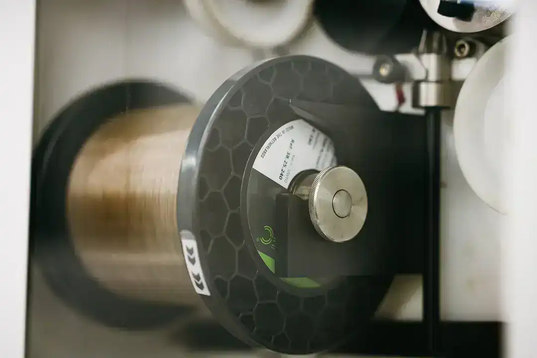 Industrial manufacturing machine with a spool of material for production.