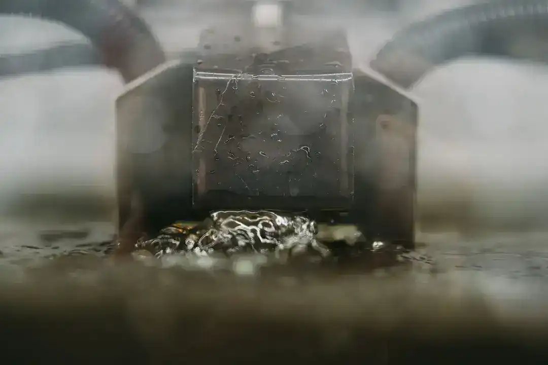 Close-up of industrial manufacturing process with water and machinery.