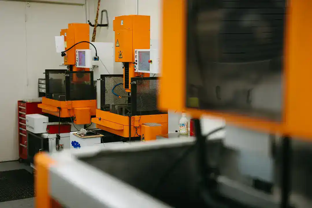 Industrial manufacturing equipment with orange machinery in a factory setting.