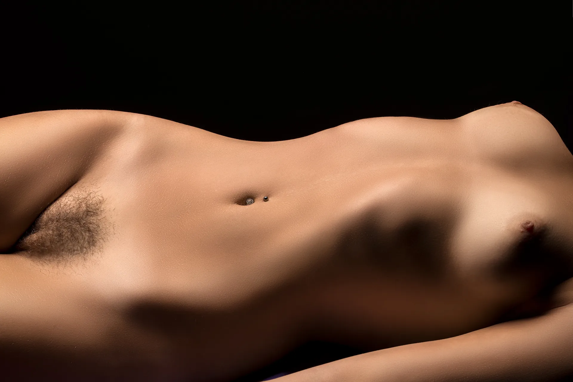 Full nude portrait of a confident woman, standing in soft natural light, celebrating the beauty and strength of the female form without concealment