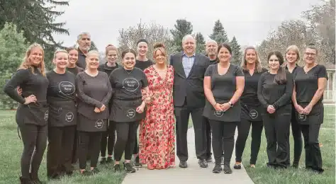 Cascades Manor staff team standing outdoors in front of a fence.