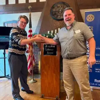 Two men shaking hands at Cascades Manor Rotary Club event.