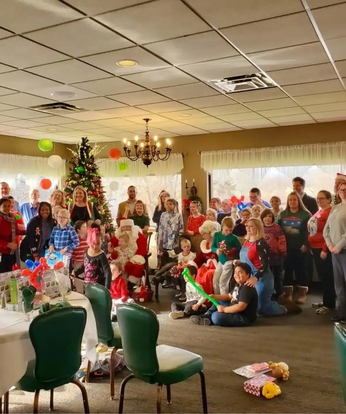 Holiday celebration with families, Christmas tree, and decorations at Cascades Manor.