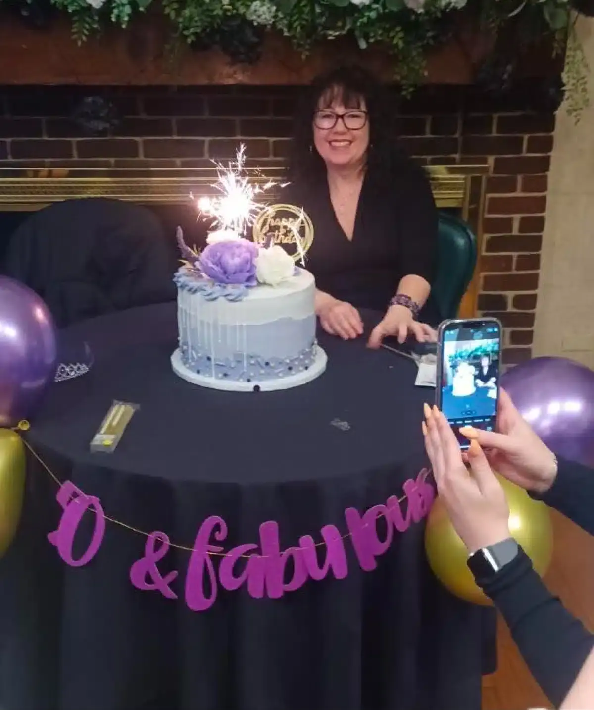 Celebration at Cascades Manor featuring a woman celebrating her birthday with a decorated cake and s.