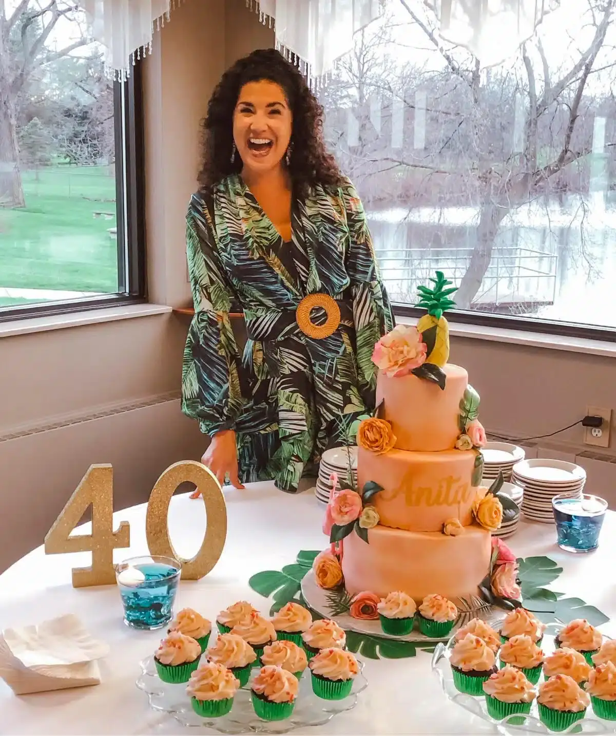 Happy woman with a cake at Cascades Manor, celebrating a 40th birthday event.