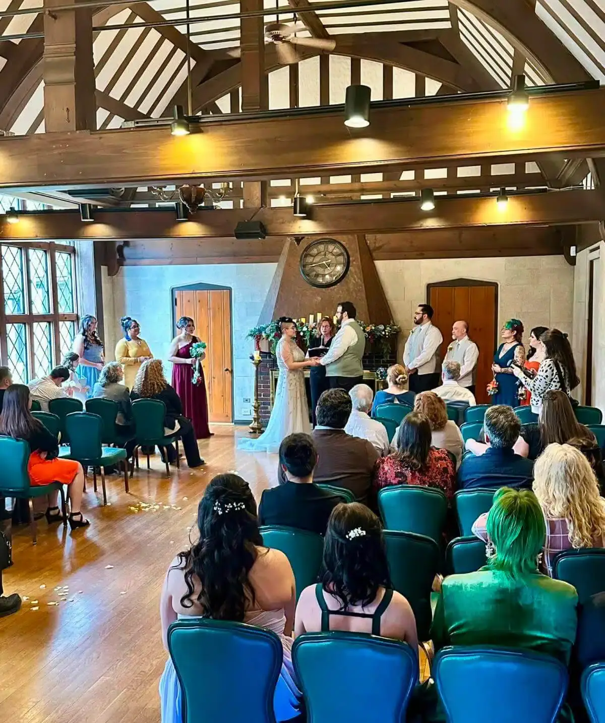 Wedding ceremony at Cascades Manor with guests seated indoors under a rustic wooden ceiling.
