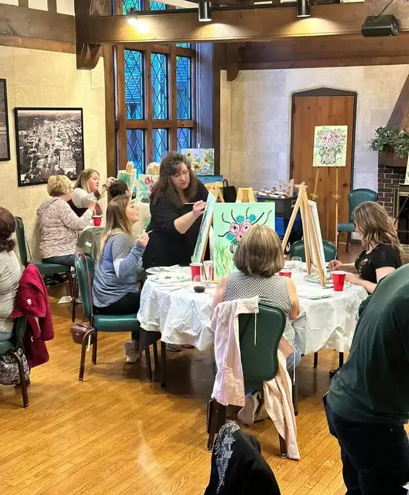 Group of people participating in a painting class at Cascades Manor event space.