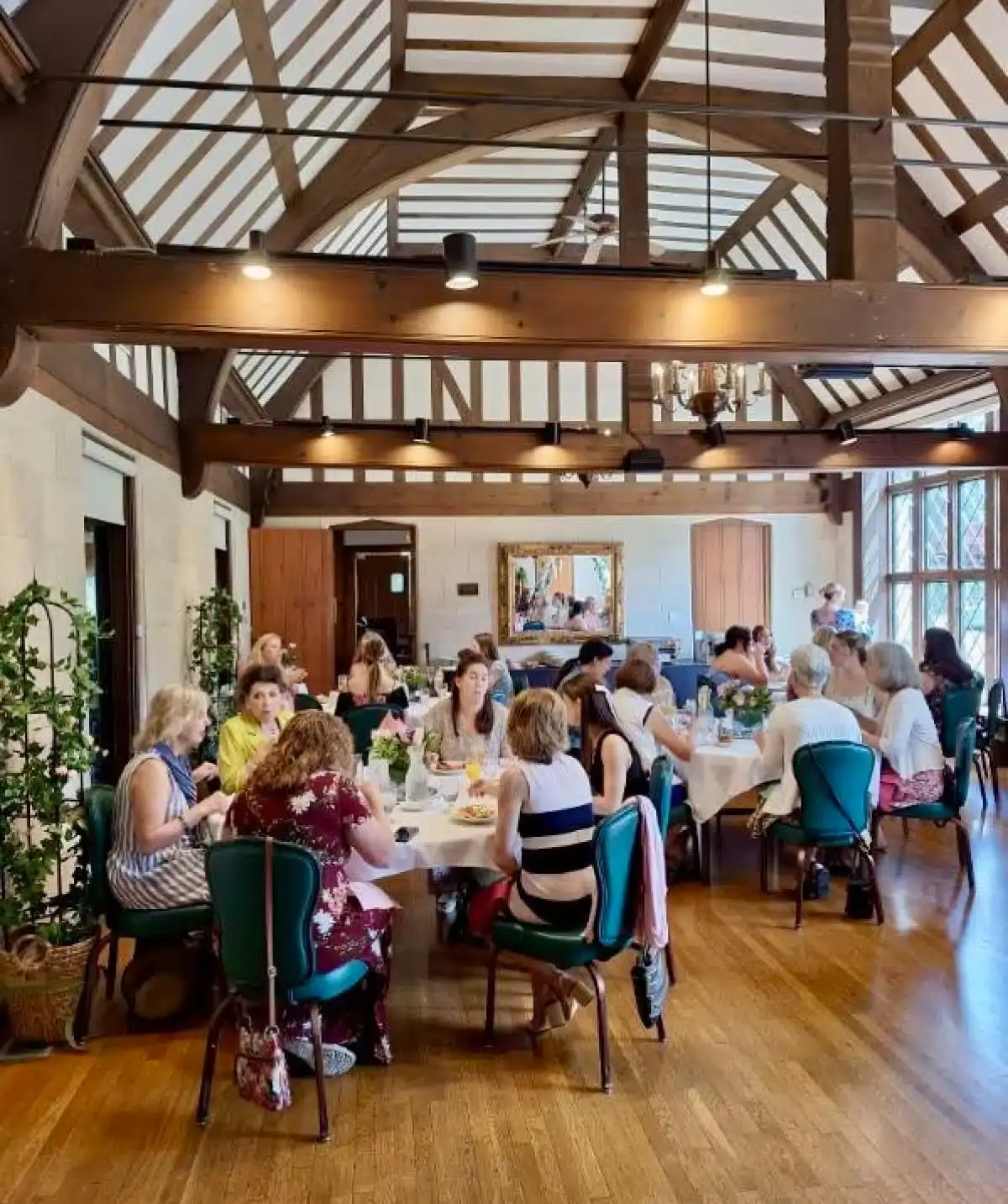 Elegant dining room at Cascades Manor with guests enjoying a meal in a rustic, spacious setting.