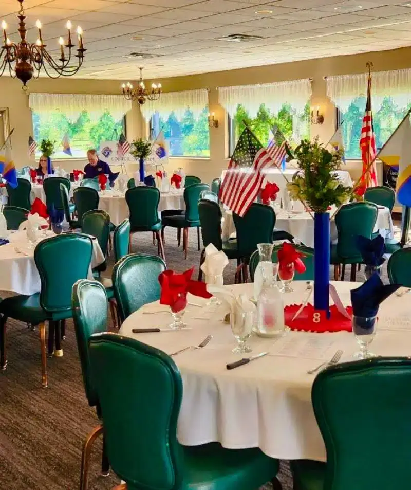 Banquet hall decorated with American flags and patriotic theme for special events.