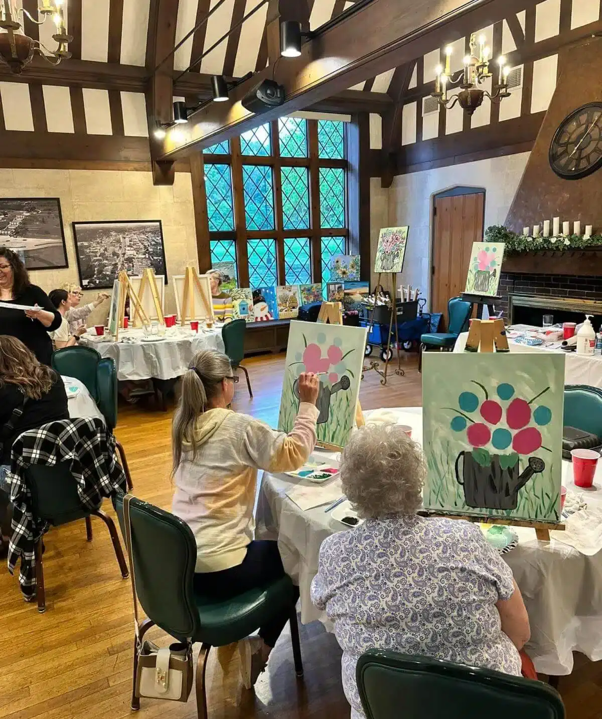 Group painting class at Cascades Manor in a cozy, rustic setting.