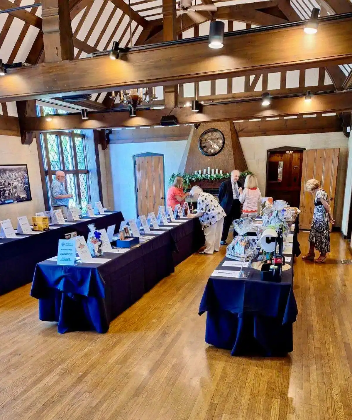 Elegant event setup at Cascades Manor with display tables and guests exploring exhibits.