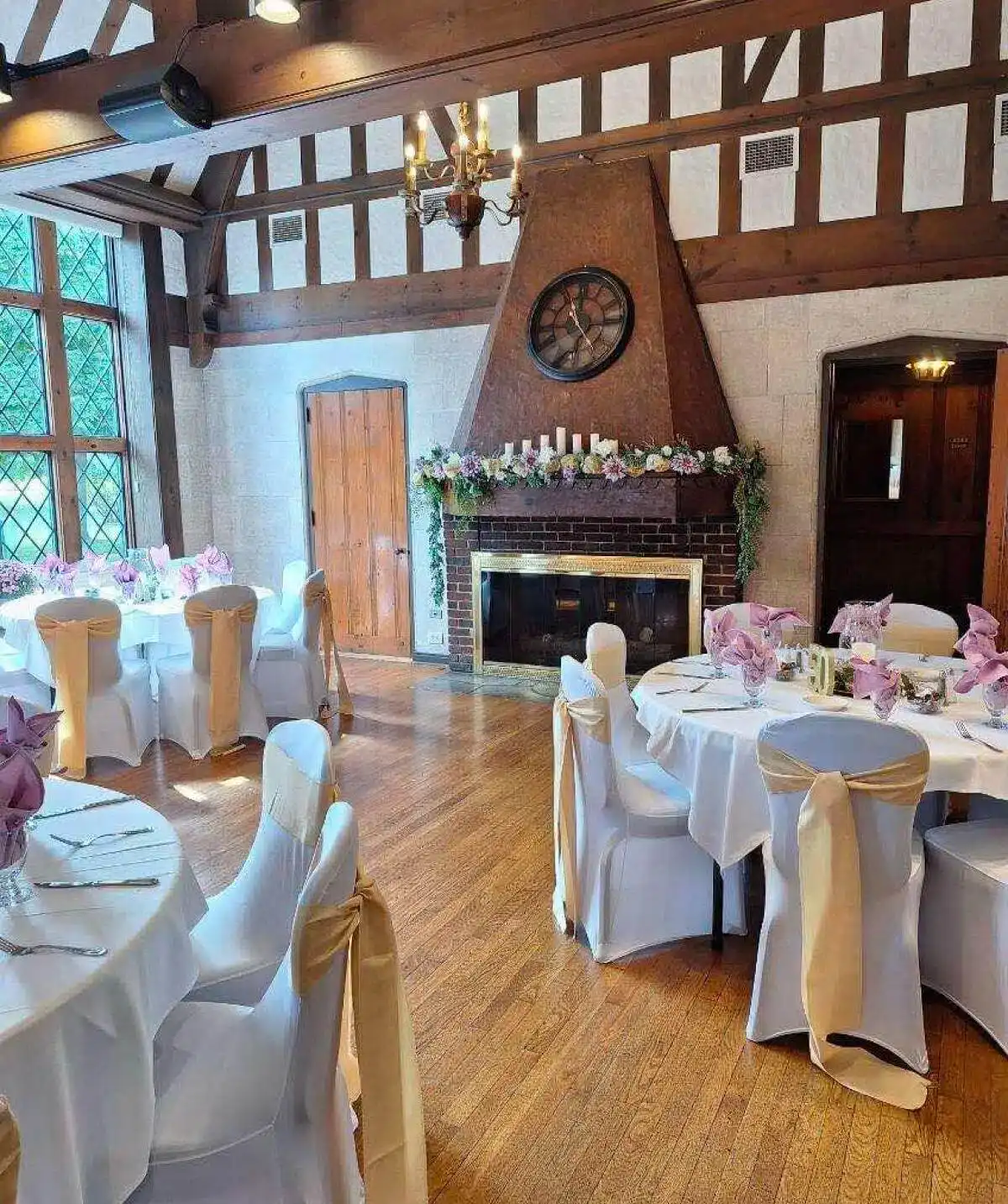 Charming indoor event space at Cascades Manor featuring decorated tables and a warm fireplace.