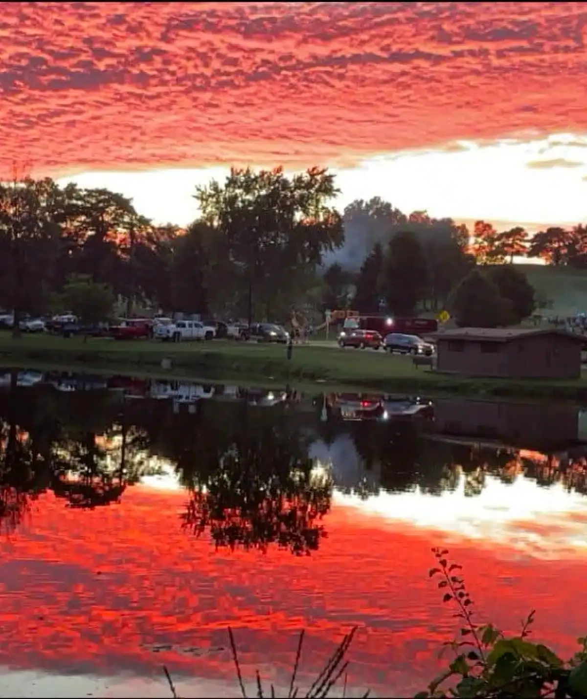 Beautiful sunset over Cascades Manor with vibrant red and orange sky reflection.