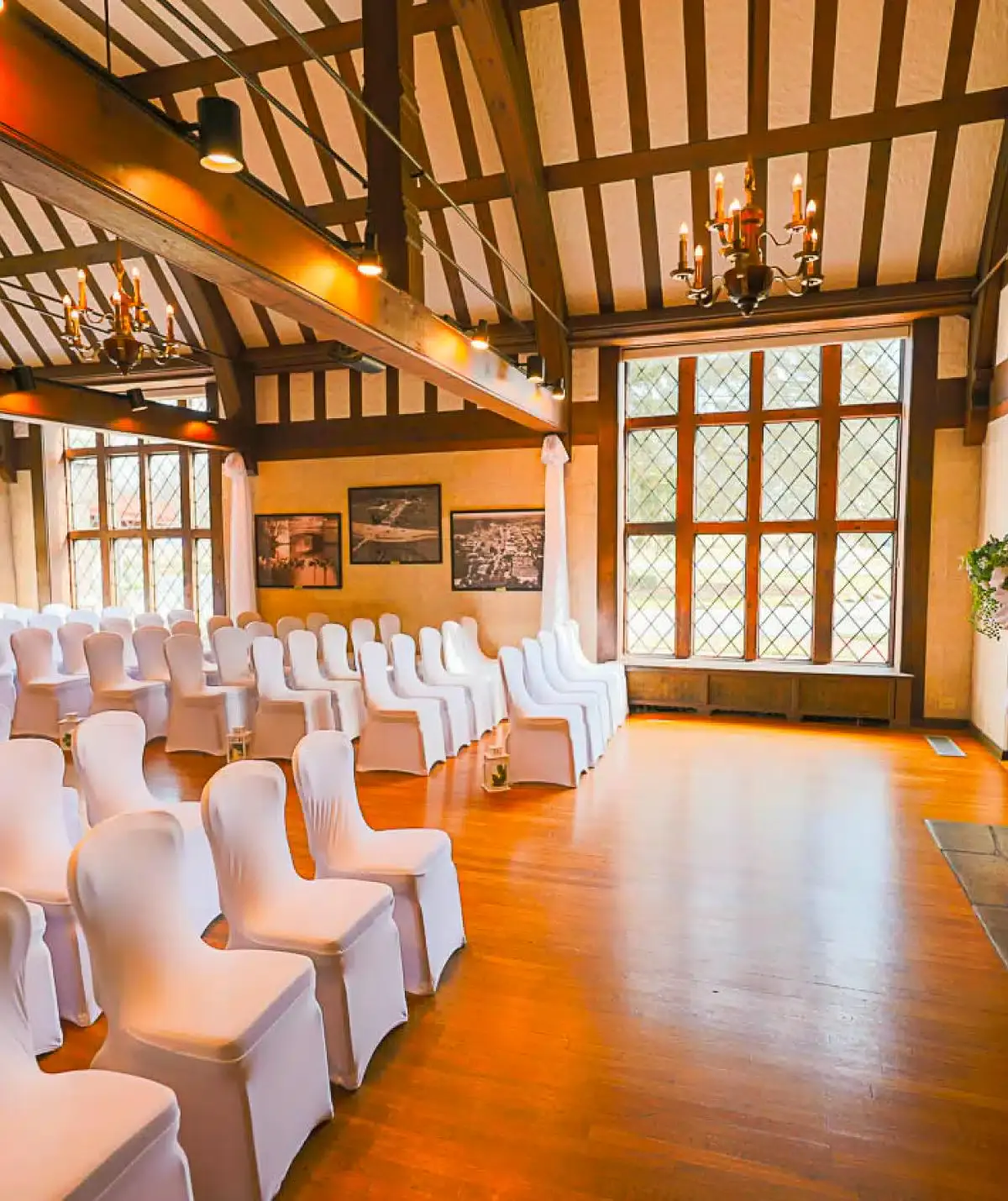 Elegant wedding ceremony room with white chairs and large windows at Cascades Manor.