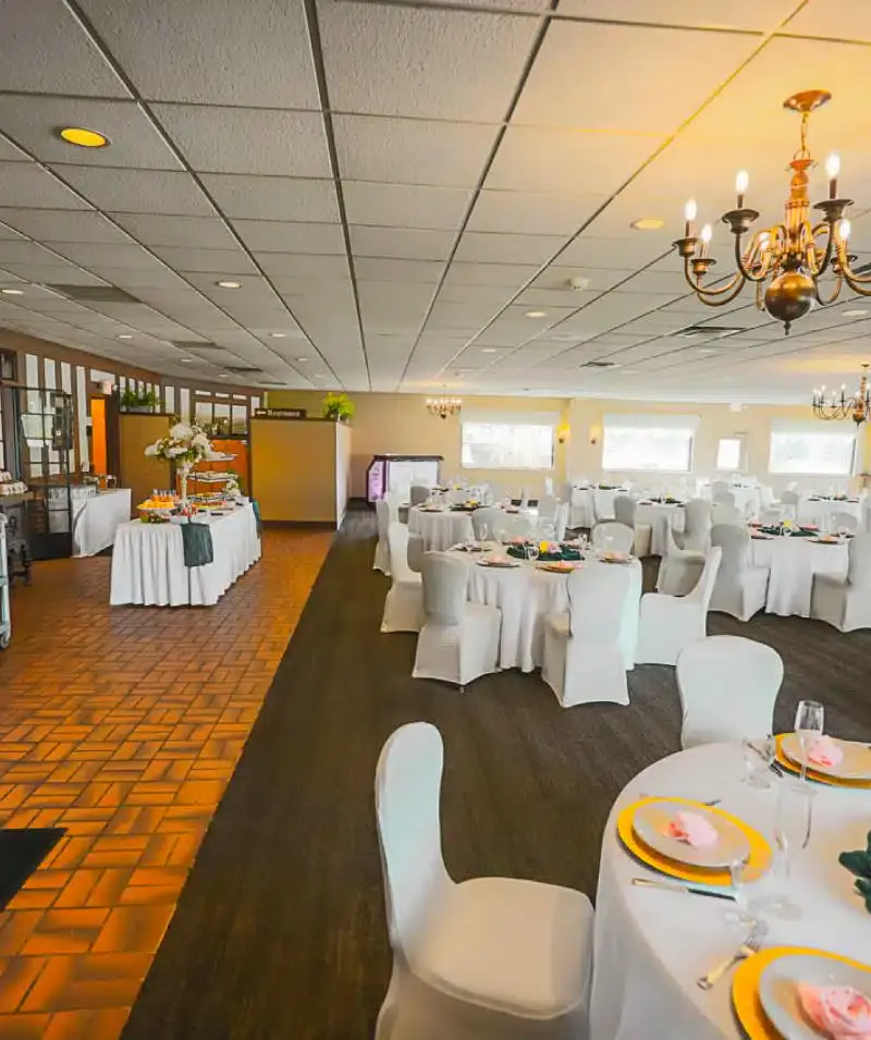 Elegant event space at Cascades Manor with round tables and white chair covers.