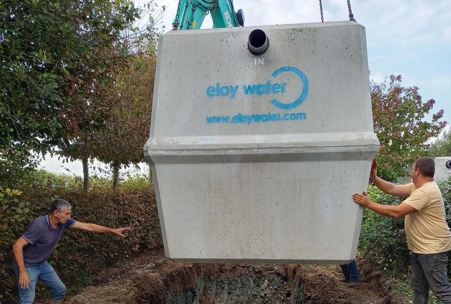 chantier : placement d'une cuve par les ouvriers au camping