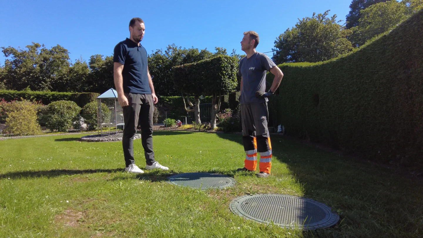 Propriétaire et opérateur certifié eloy inspectant un filtre compact d’assainissement dans un jardin