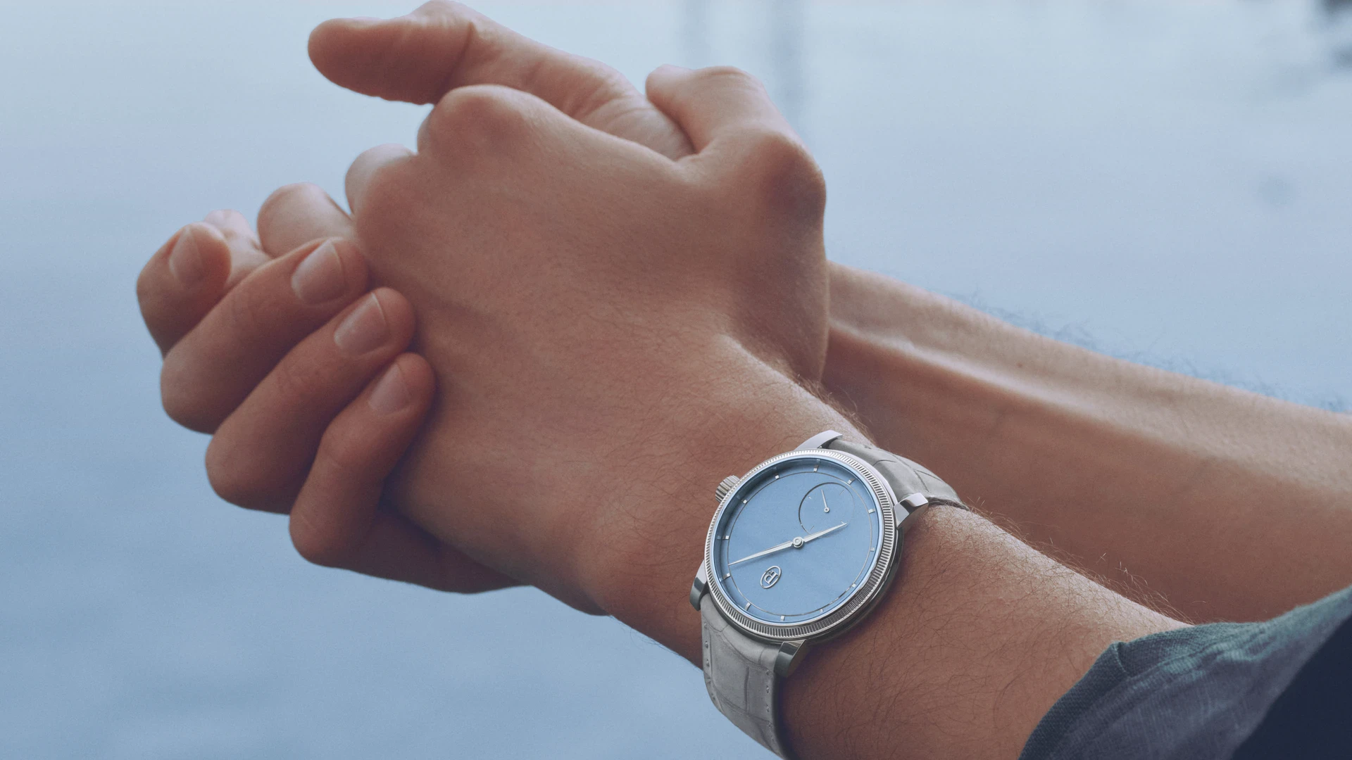 Parmigiani Fleurier Toric Petite Seconde Morning Blue in platinum worn on the wrist, with its pale blue hand-grained dial and grey nubuck strap