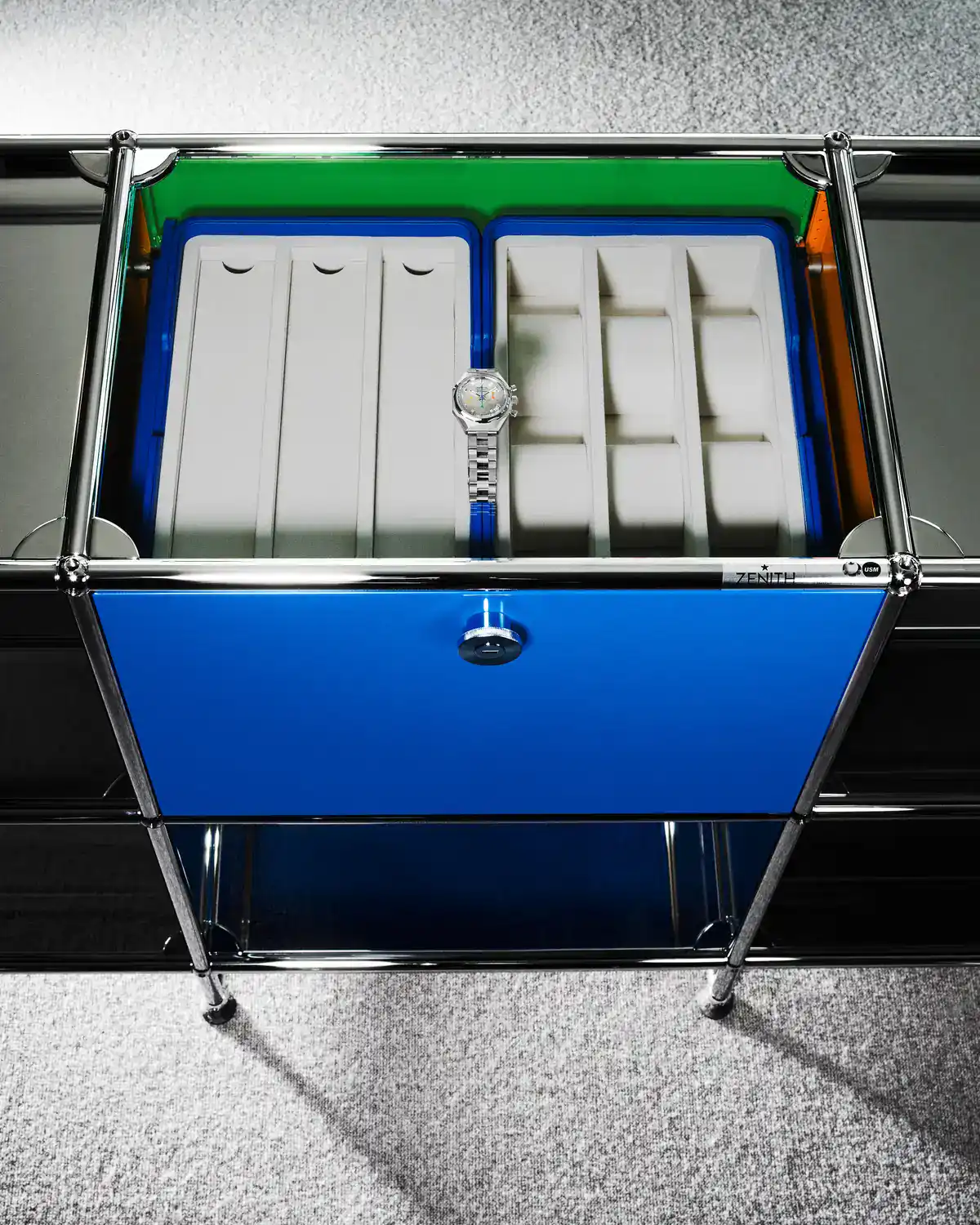 Zenith DEFY Chronograph USM TimeForArt Unique Piece alone in the open watch drawer of the mirrored USM Haller sideboard, above a blue lockable front