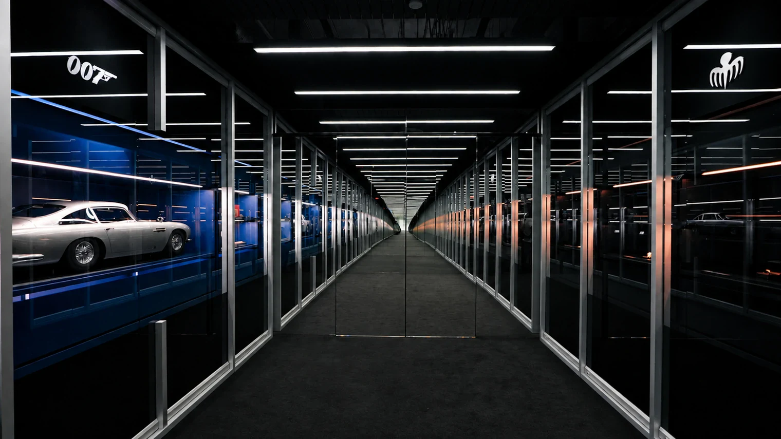 The facing James Bond and Spectre archives at the Omega Seamaster James Bond Spectre exhibition in Glendale: a corridor of lit glass shelving with the 007 logo on one side and the Spectre emblem on the other