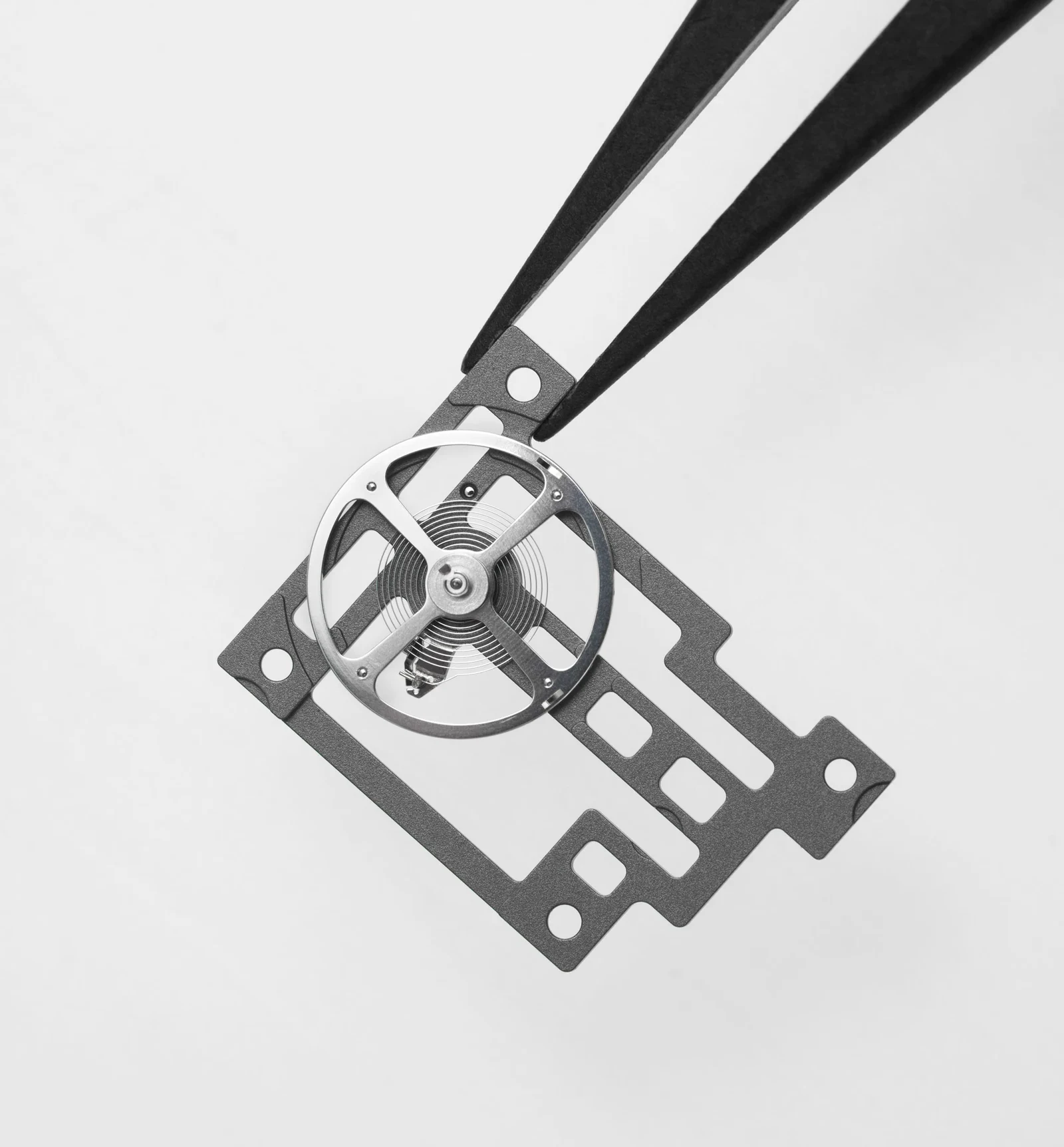 Skeletonised grade 5 titanium baseplate of the Richard Mille Calibre CRMA9 held in tweezers, the movement inside the Jeremy Strong Richard Mille RM 16-02