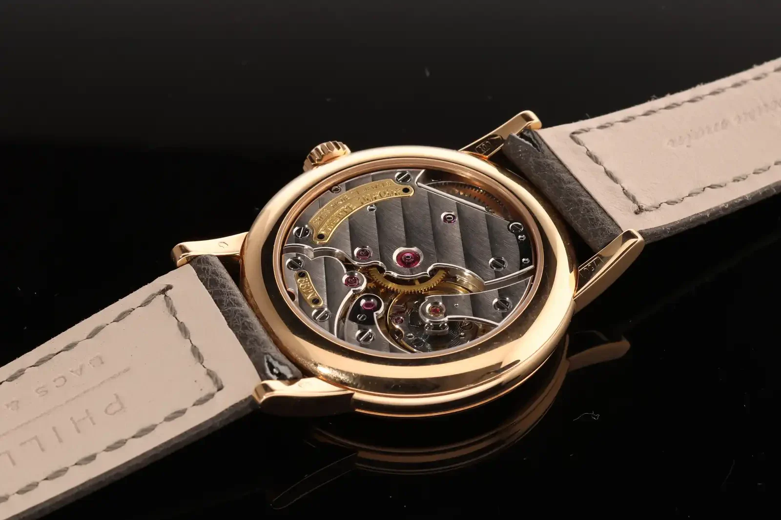 Philippe Dufour Simplicity auction lot No. 199 seen through its sapphire caseback, showing the striped movement bridges and gold signature plate