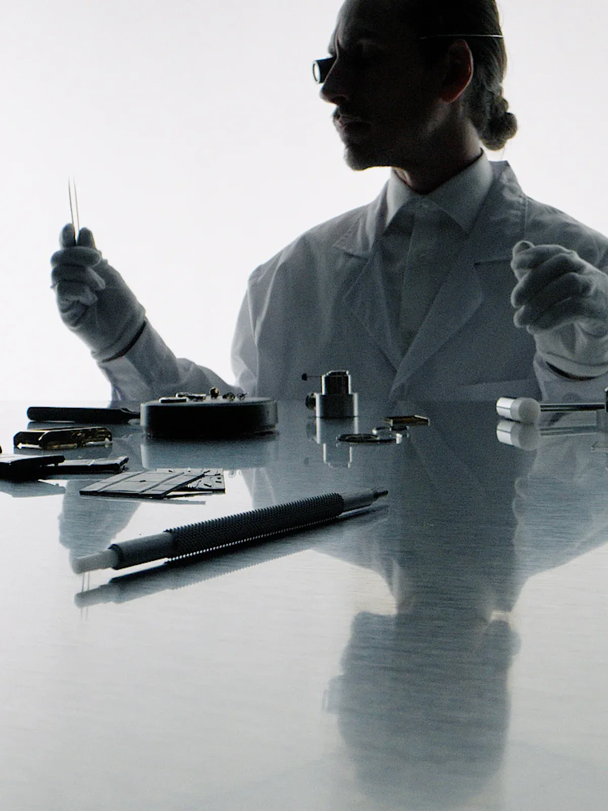 Swiss watchmaker in a white coat assembling VIEREN Gold Croc components at a workbench