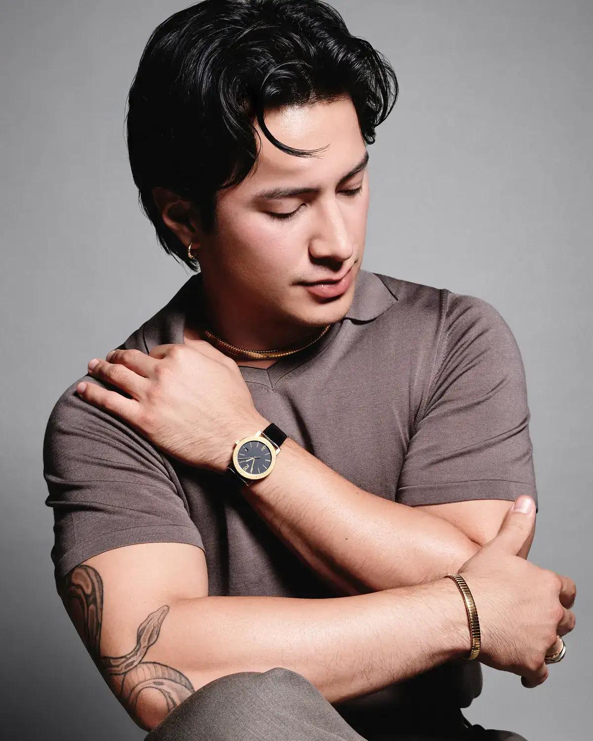 Hudson Williams Bulgari ambassador Hudson Williams with a gold watch and gold bracelet in an official portrait