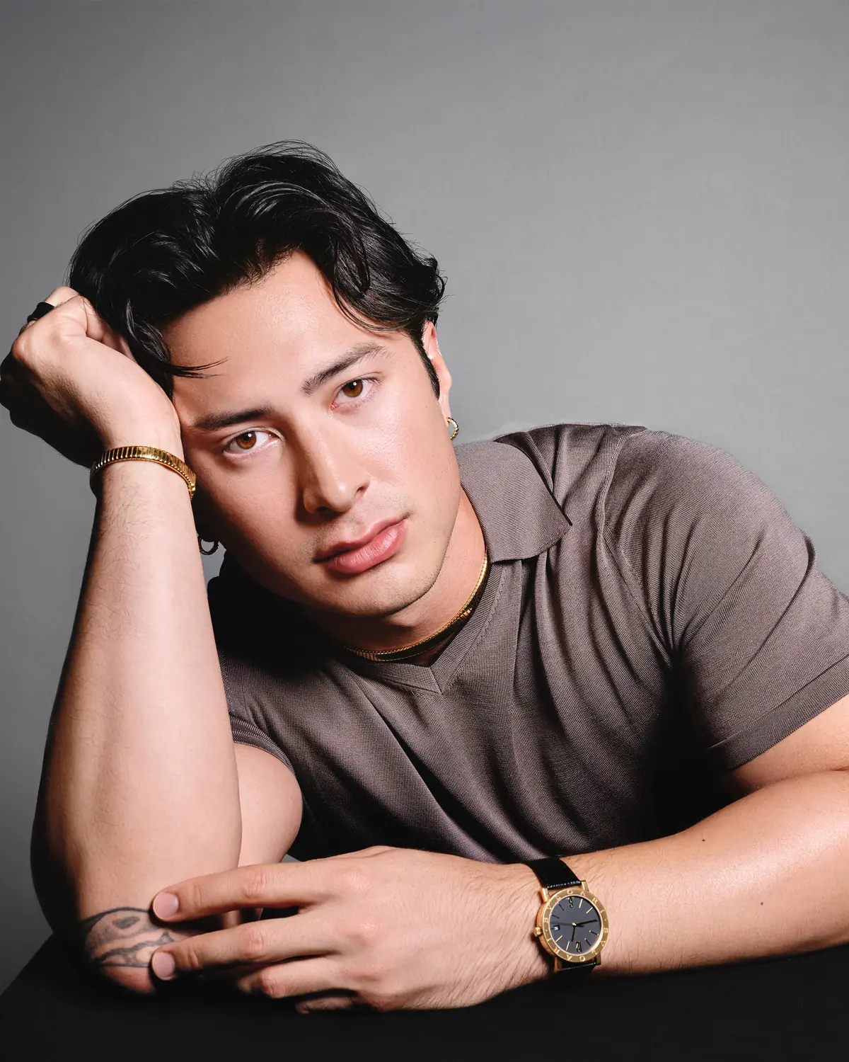 Hudson Williams Bulgari ambassador Hudson Williams wearing a gold bracelet, rings and a gold watch