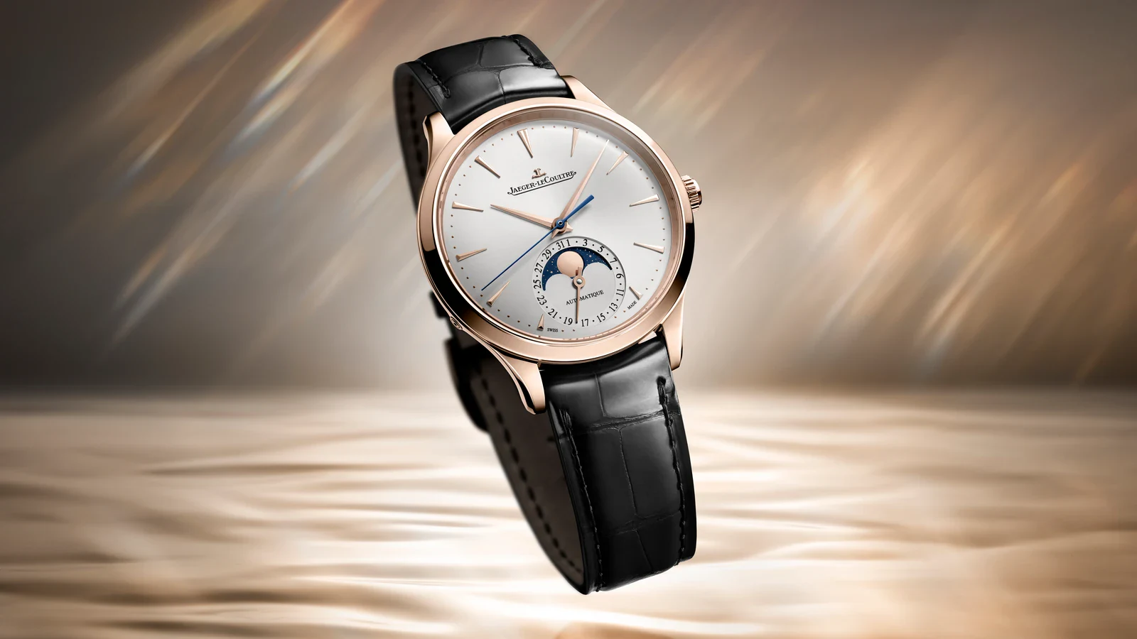 Jaeger-LeCoultre Master Ultra Thin Moon in pink gold suspended against a golden backdrop