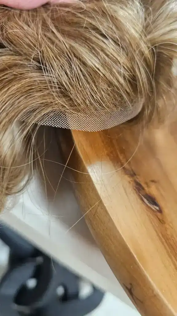 Close-up of a blonde wig hairpiece on a mannequin head.
