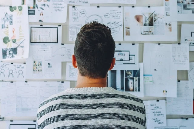 Website-hero-design-Visual-Creativity-Design-Whiteboard-Workspace.jpg alt text: Man analyzing a whiteboard filled with sketches, notes, and design concepts, representing creative planning and brainstorming for innovative projects caption: A man reviews various sketches and plans on a whiteboard, showcasing creative collaboration and project development image description: The image depicts a man from behind, standing in front of a whiteboard covered with sketches, notes, and diagrams, highlighting creative thinking, planning, and brainstorming in a professional workspace relevance: Relevant, as it reflects creative planning and project development themes typical for Linked Tea's content.