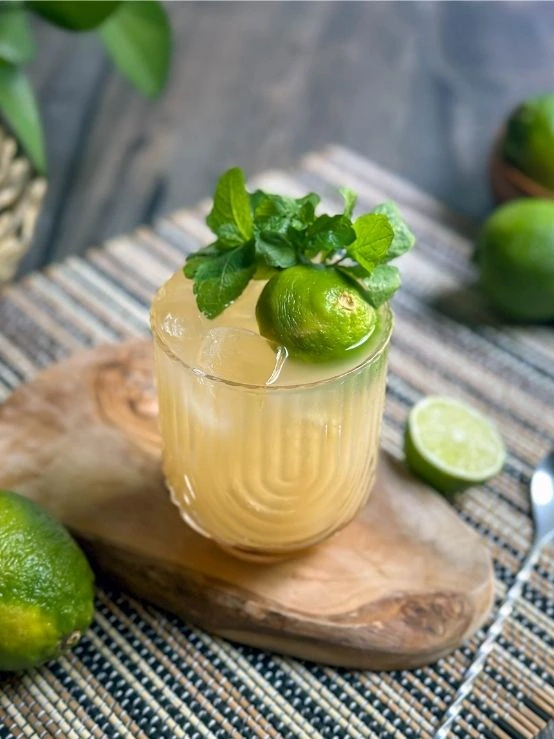 Trader Vic's original Mai Tai cocktail garnished with lime and fresh mint served over ice in a short rocks glass.