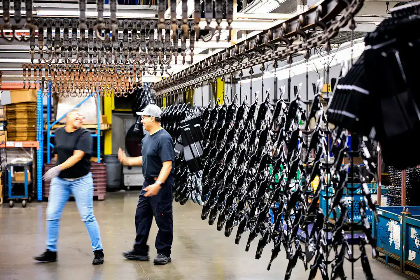 Workers inspecting equipment in a large industrial warehouse.