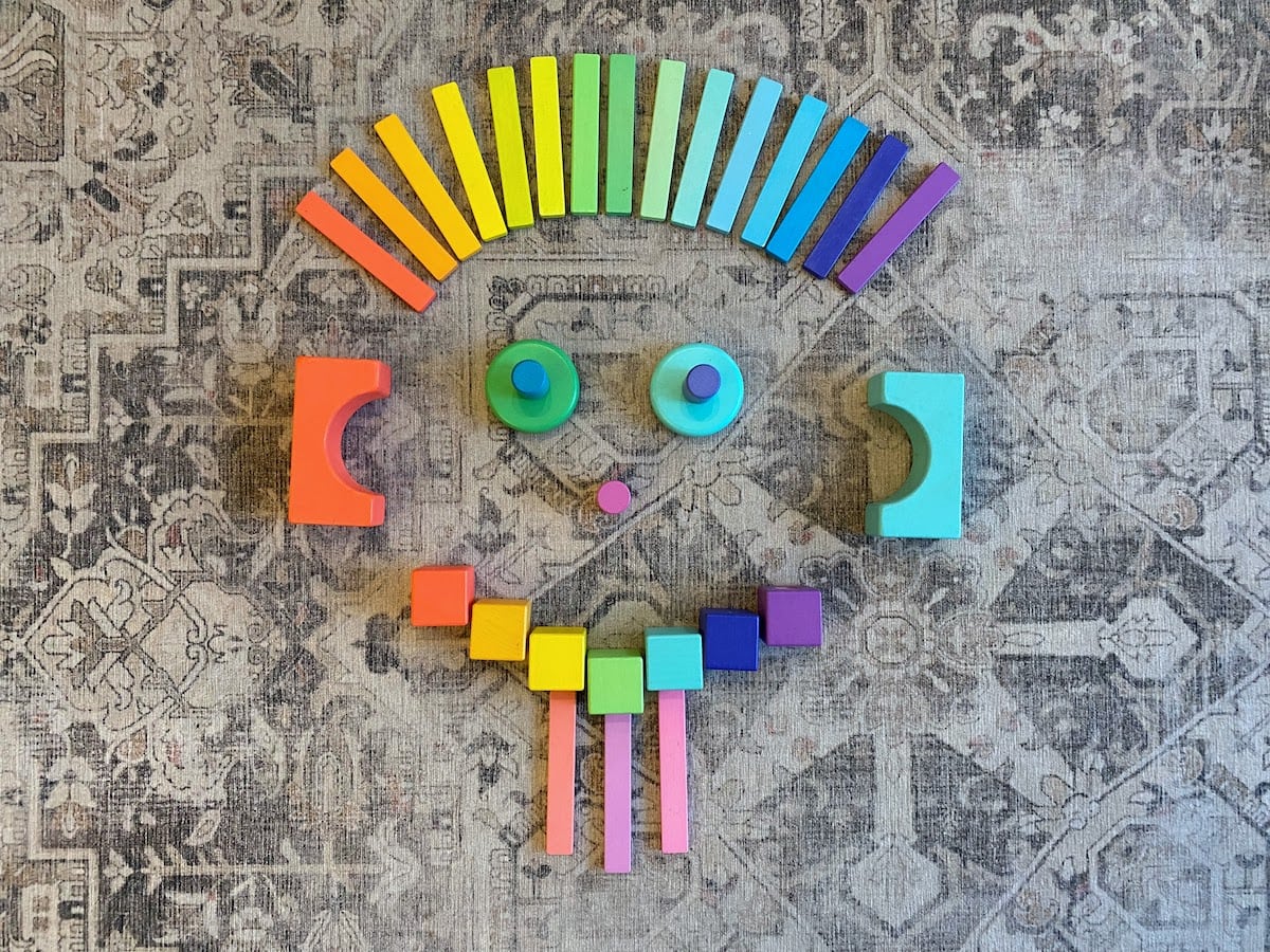 A face made out of a rainbow of wooden blocks by Lovevery