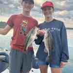 A young man and woman each hold fish caught with Badock Fishing Guide Service while at Table Rock Lake in southwest Missouri near Branson.