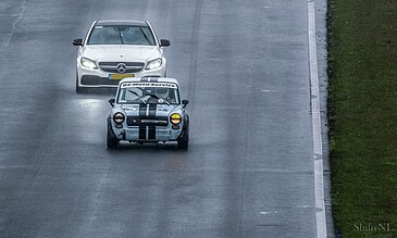 1. Vintage race car and modern Mercedes-Benz on rainy race track, capturing adrenaline-filled racing moments.