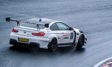 High-performance BMW M6 GT3 racing car on wet track, showcasing professional motorsport photography and adrenaline-filled racing moments.
