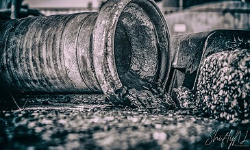 1. Industrial pipe leaking dark oil or sludge in a factory setting, showcasing industrial machinery and corrosion.